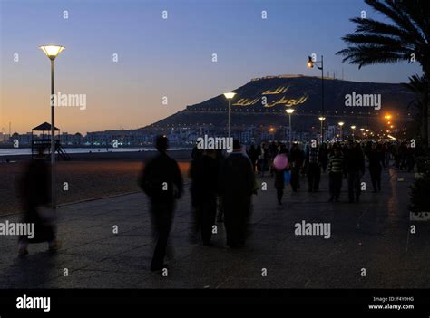 People walking along Agadir beach at sunset Stock Photo - Alamy