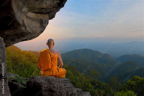 Buddhist monk in meditation Under the big stones in nature on high ...