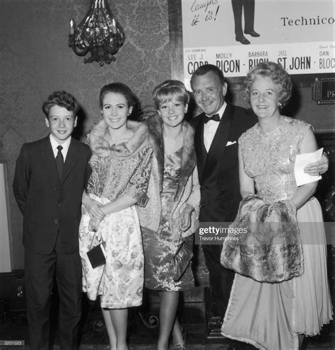 a group of people standing next to each other in front of a wall with ...