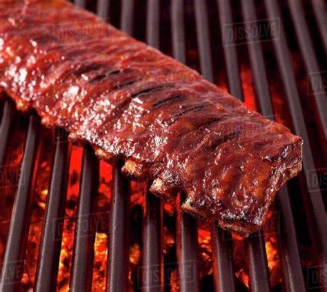 Whole Rack of Pork Ribs on Grill with Barbecue Sauce - Stock Photo ...