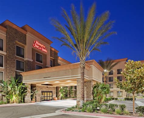 the exterior of a hotel with palm trees in front of it at night and ...