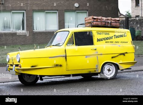 Vintage robin reliant yellow three wheeled car on council estate ...