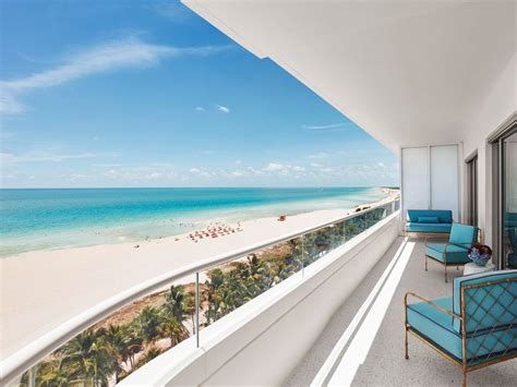 a balcony with blue chairs overlooking the beach