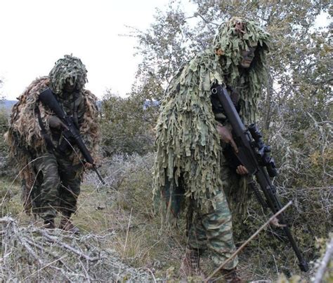 Snipers wearing ghillie suits move in a forest | Download Scientific ...