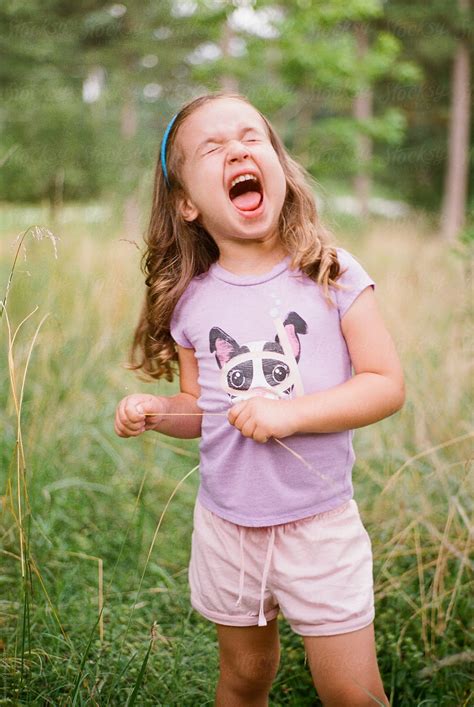 Cute Young Girl Making A Funny Face In A Field By Stocksy Contributor ...