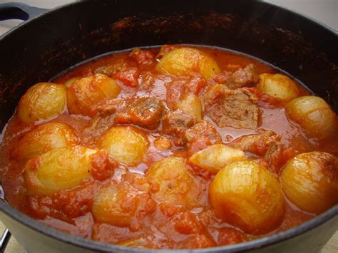 a pot filled with stew and potatoes on top of a stove