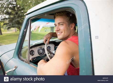 Man driving truck in field Stock Photo - Alamy