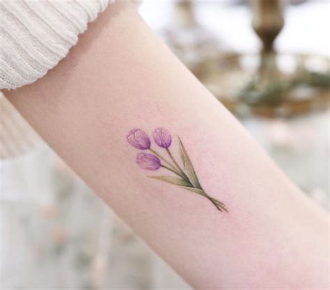 a woman's arm with purple flowers on it