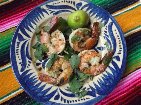 a blue and white plate topped with shrimp and veggies next to an apple