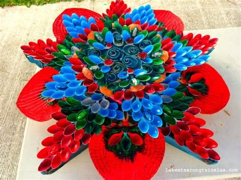 an arrangement of red, blue and green flowers on top of a white tablecloth