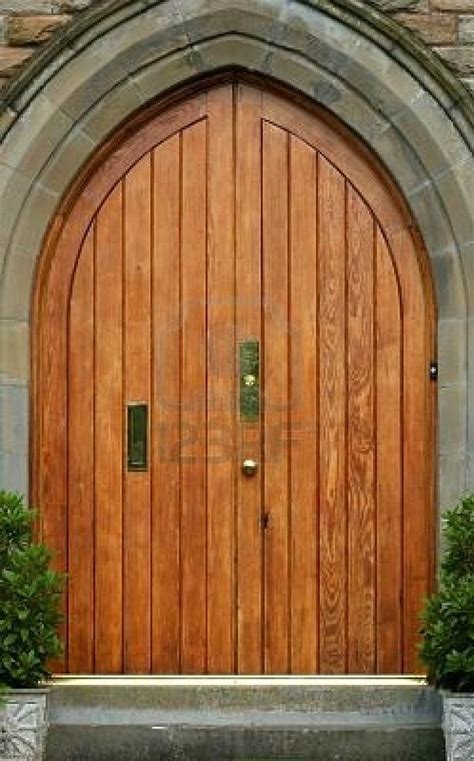 a large wooden door sitting in the middle of a stone wall next to two ...