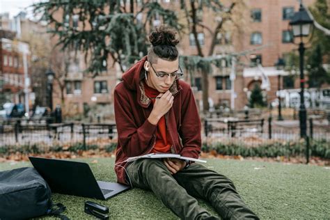 Guy studying with laptop and notebook on grass in park · Free Stock Photo