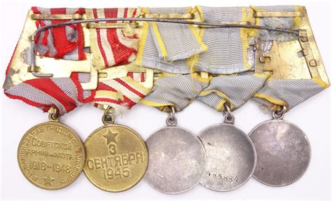 Group of Soviet medals consisting of 3 medals for Combat Merit, Medal ...