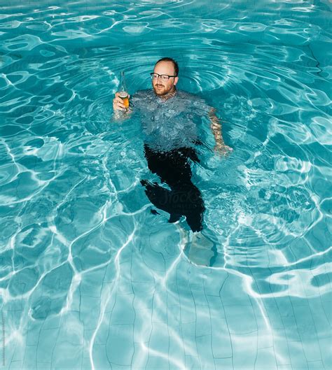 "Young Fully Clothed Male Drinks A Beer While Swimming In A Pool During ...