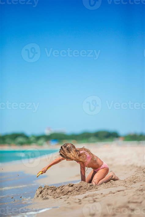 Adorable little girl playing with beach toys during tropical vacation ...