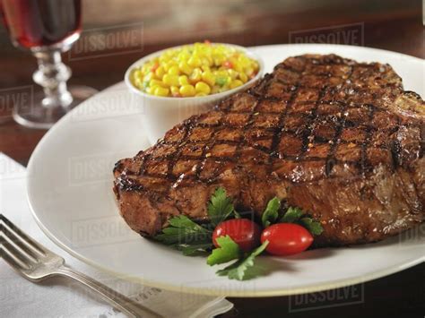 Grilled Porterhouse Steak with a Side of Corn - Stock Photo - Dissolve