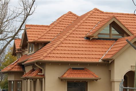 a house with red tile roofing and windows