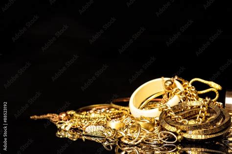 Bunch of gold jewelry against black background with copy space for text ...