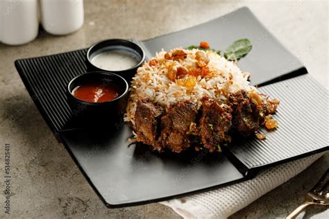 Mutton Biryani with raita and sauce served in a dish isolated on grey ...