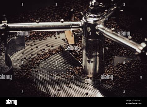 Close up of beans in a stainless steel industrial coffee roaster for an ...