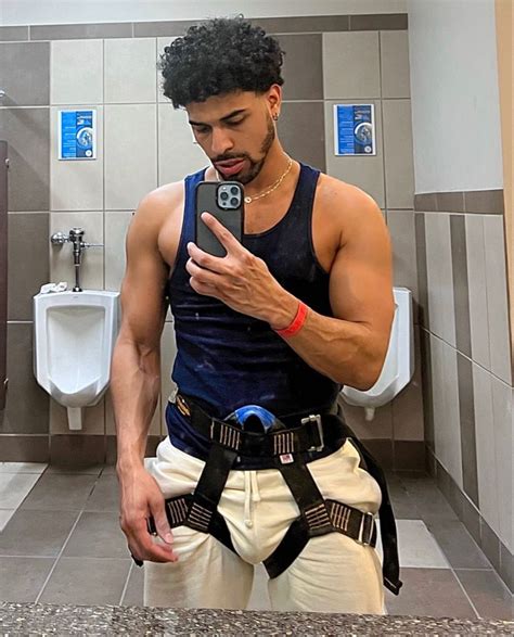 a man taking a selfie in a bathroom with his cell phone and harness ...