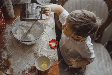 Free Photo | Little boy in the kitchen helps mom to cook. the child is ...