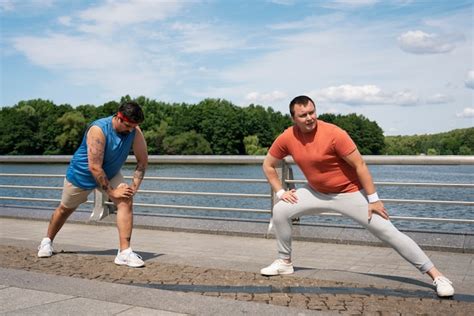 Premium Photo | Full shot men exercising together outdoors