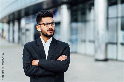 A modern Indian office worker, a bearded handsome Indian man, behind ...