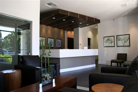 a living room filled with black furniture and lots of windows