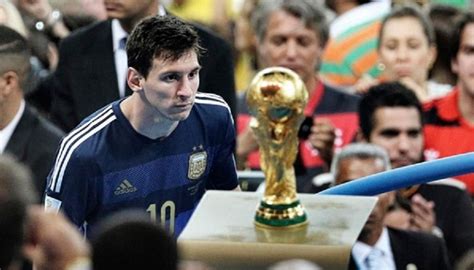 a man standing next to a golden trophy in front of a large group of people