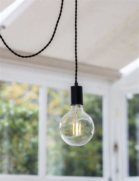 Soho Pendant Light in Black hanging in a conservatory. Click to shop ...