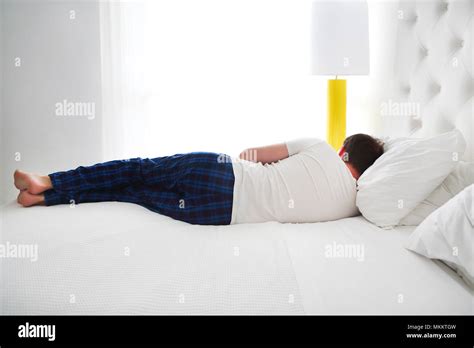 Young man sleeping in the bed room. back view Stock Photo - Alamy