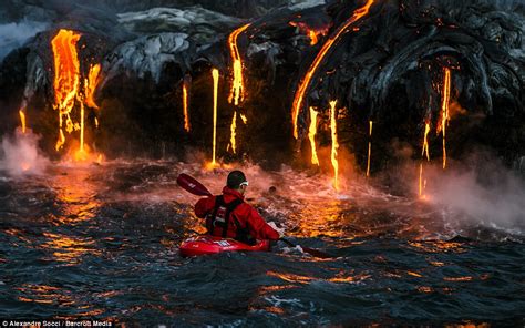 Daredevil kayaker's oar catches fire as he explores coastline beneath ...