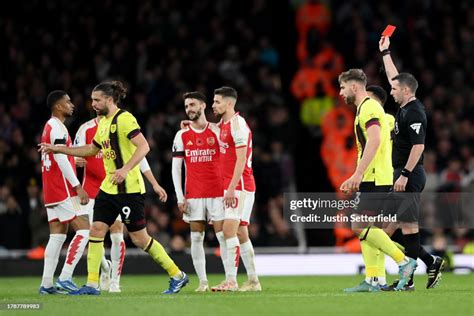 Referee Michael Oliver shows a red card to Fabio Vieira of Arsenal ...