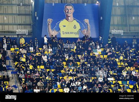 Al Nassr fans sit under a giant billboard of Cristiano Ronaldo during ...