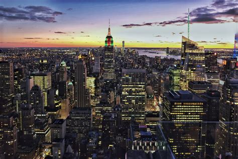 view of the new york city skyline from top of the rock at sunset, the ...