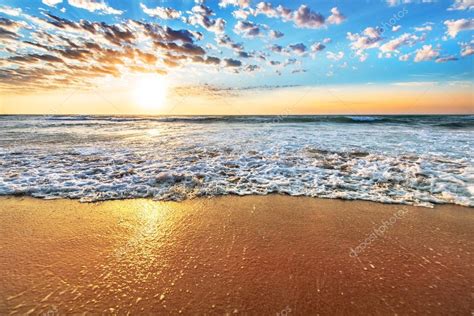 Nascer do sol colorido praia oceano com céu azul profundo e raios de ...