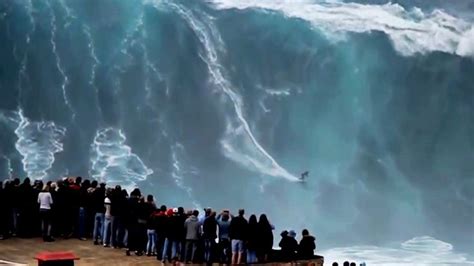 a group of people watching a large wave