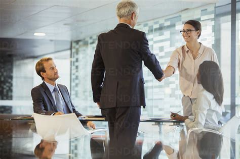 Business people shaking hands in office building stock photo