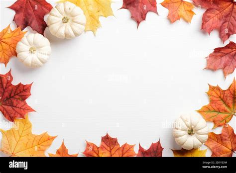 Autumn leaves and pumpkins border frame on white table. Seasonal ...