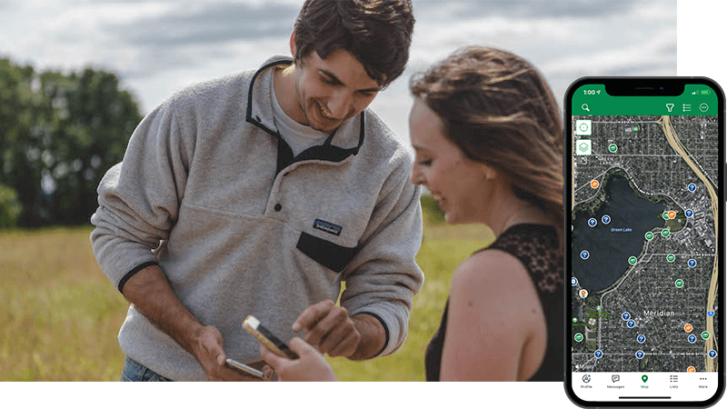 Two adults look at a smartphone screen. 