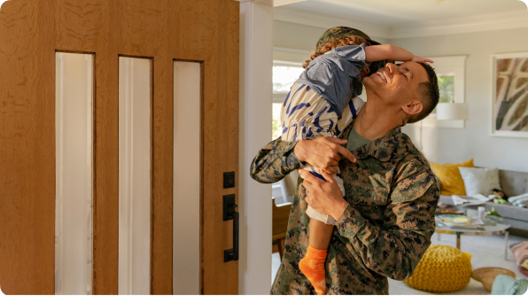 Man wearing army uniform hugging his daughter 