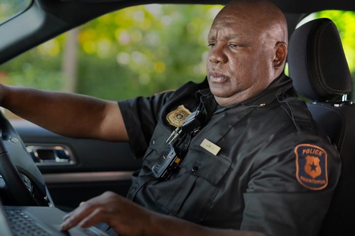 Police officer sitting in patrol car