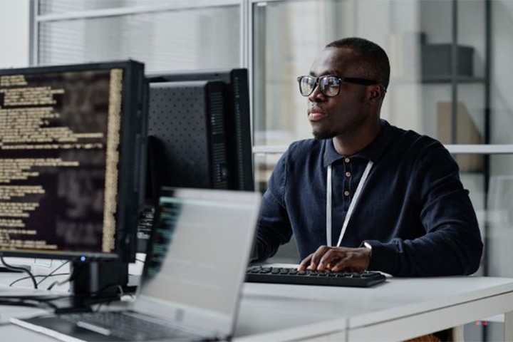 Code developer reviewing data on desktop computer