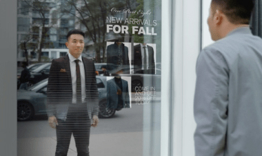 man looking at his reflection outside a store