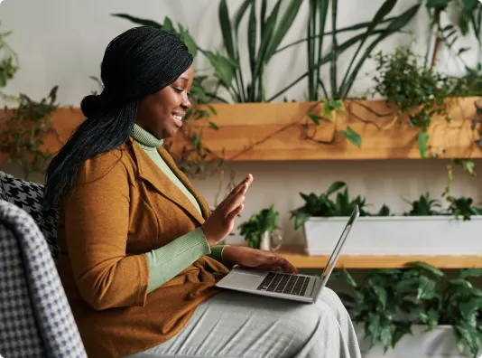 a woman sitting on a couch using a laptop computer