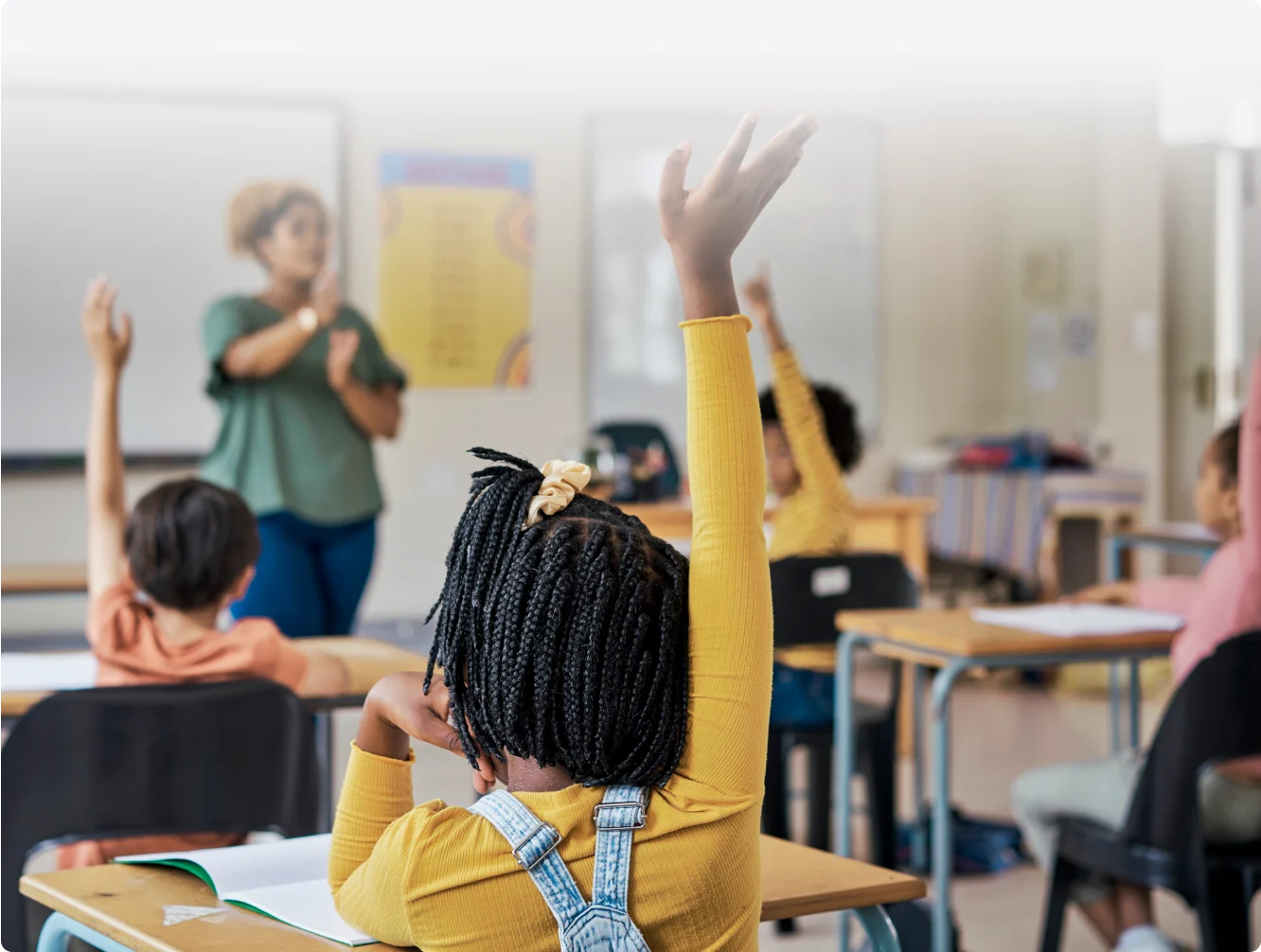 Enseignant participant au programme TELUS Averti devant une classe d’enfants qui lèvent la main