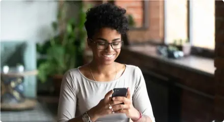 A person uses a phone as a hippo steps out of a smartphone, symbolizing that the device is protected by Device Care Complete.