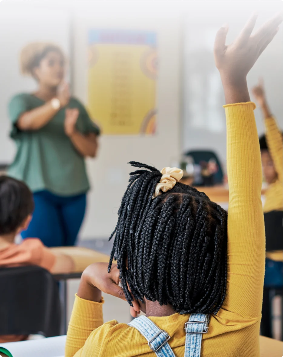 Enseignant participant au programme TELUS Averti devant une classe d’enfants qui lèvent la main