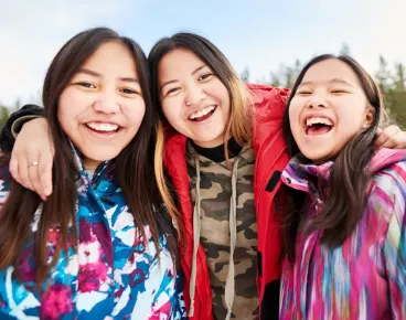 A trio of smiling teenage girls